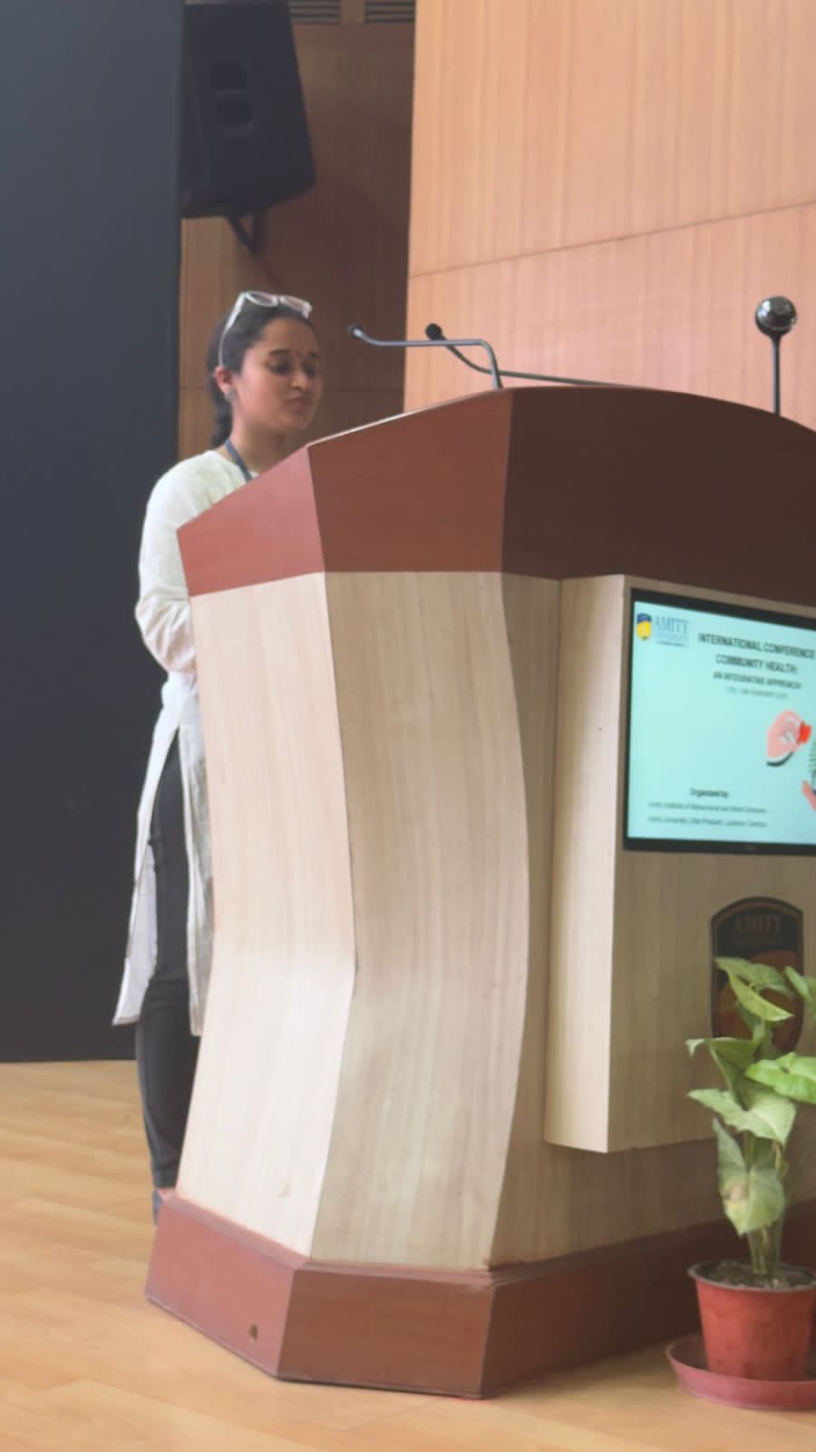 Speaker presenting at an academic conference podium